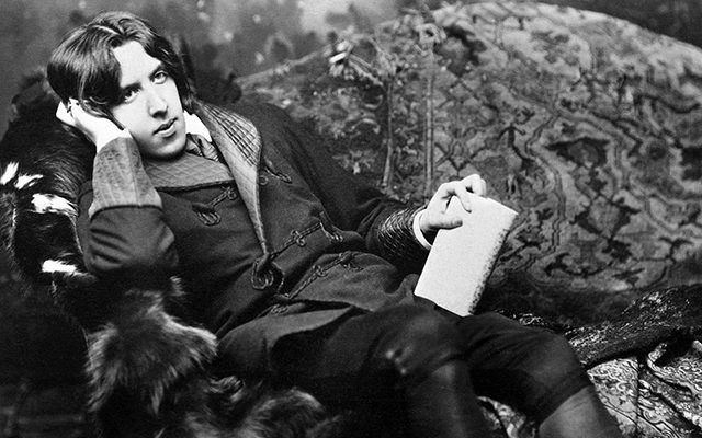 Oscar Wilde, thinking. Oscar Wilde the writer sprawled out on a fancy couch.
