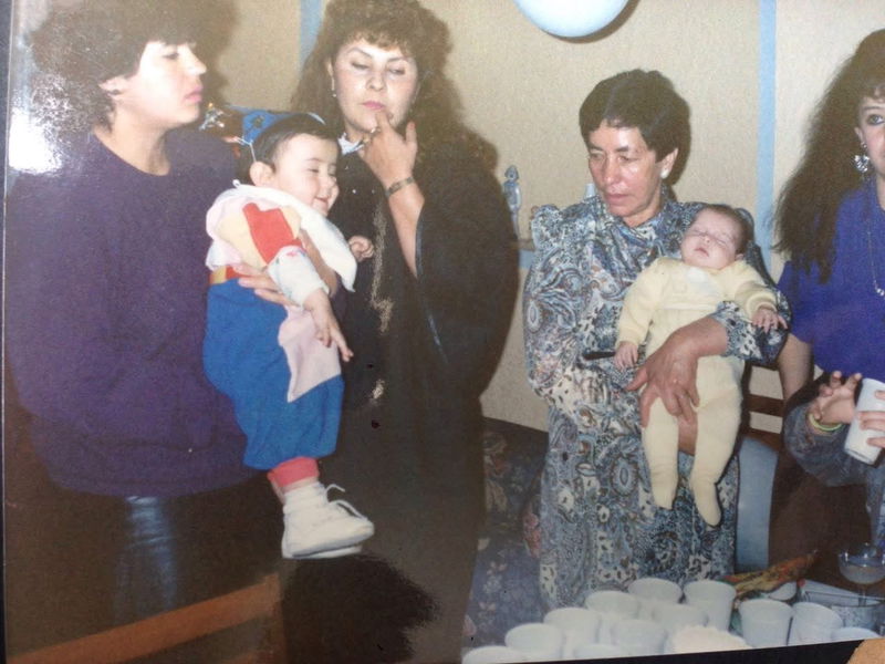 My mom holding me while my grandma is watching my during my birthday