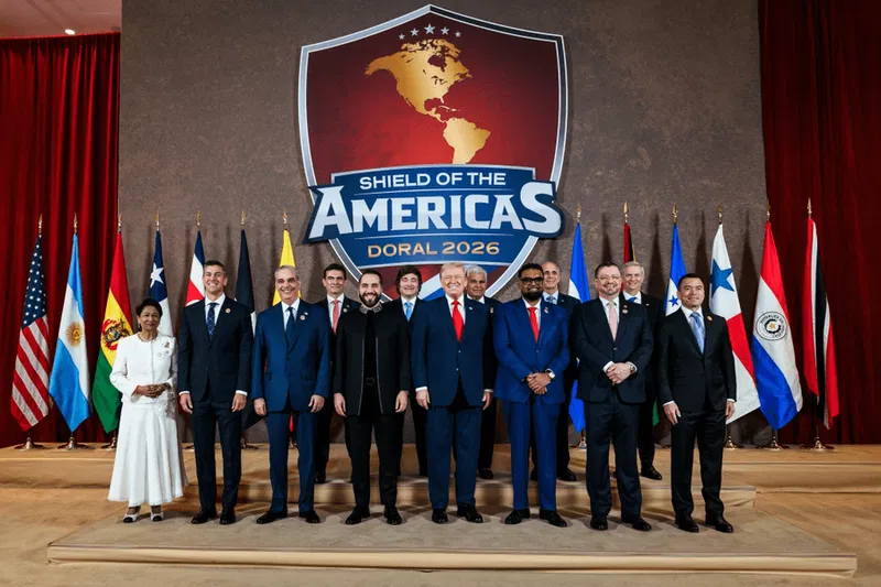 A group photo of political leaders at the 'Shield of the Americas' event in Doral 2026, featuring flags from various countries and a central logo.